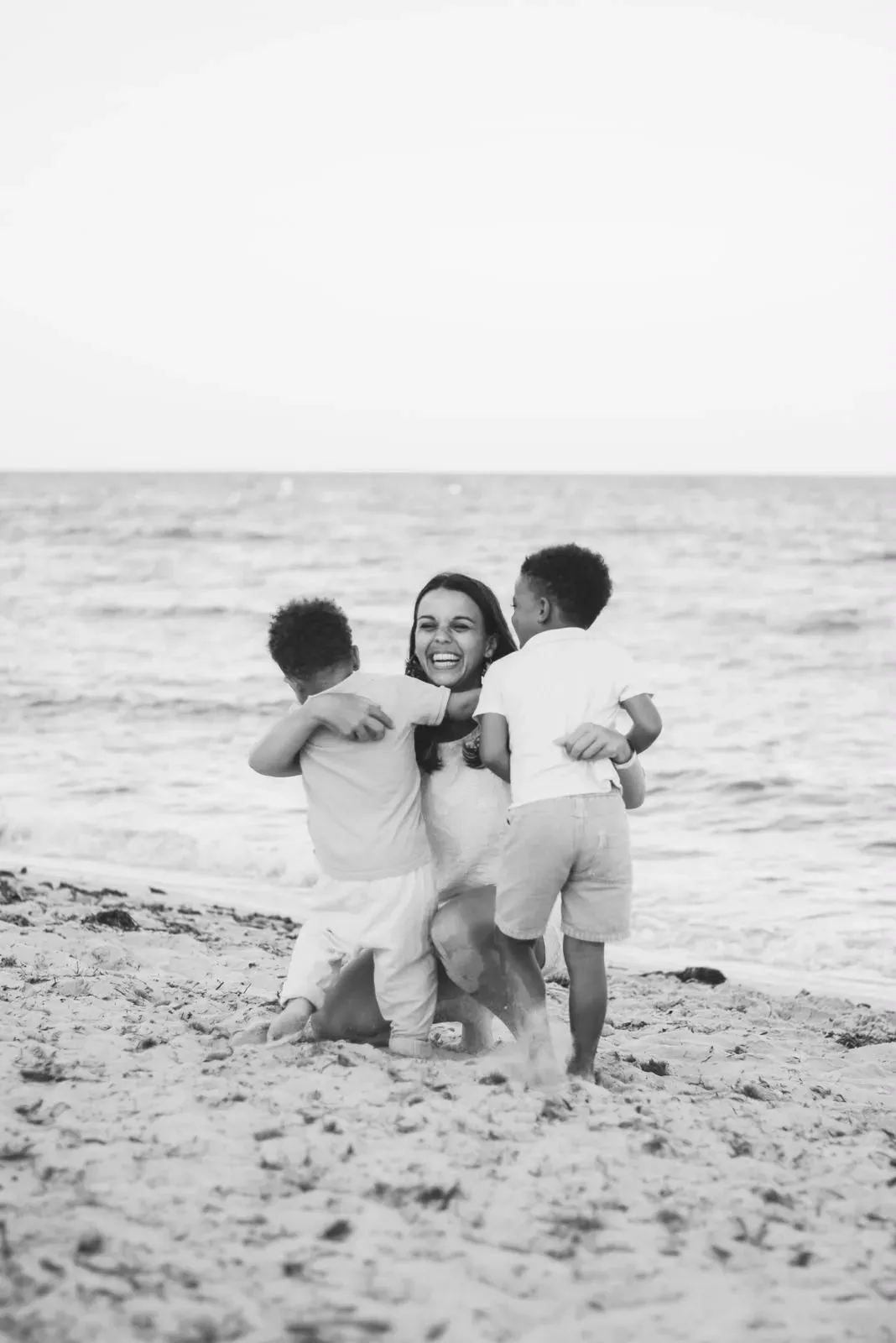 Alix riant avec ses deux garçons sur la plage